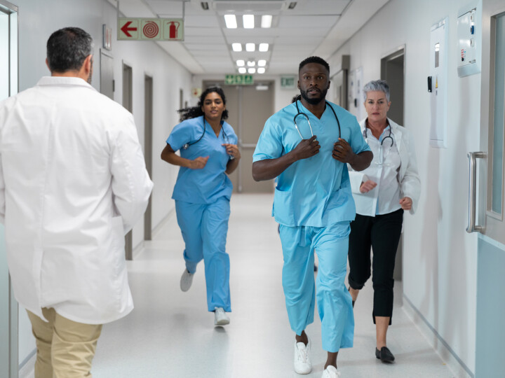 diverse group of medical staff running in hospital