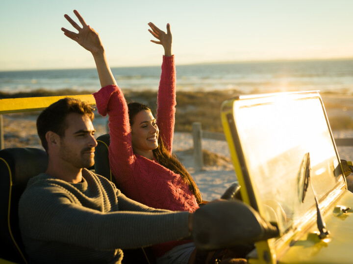 happy couple sitting in moving car