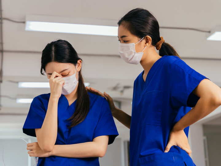 stressed and frustrated nurse getting comforted