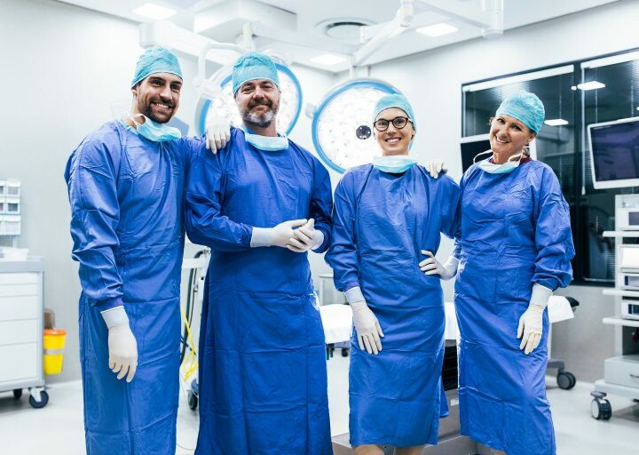 four doctors standing in operating room