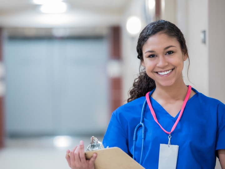 young nurse smiling holding clipboard
