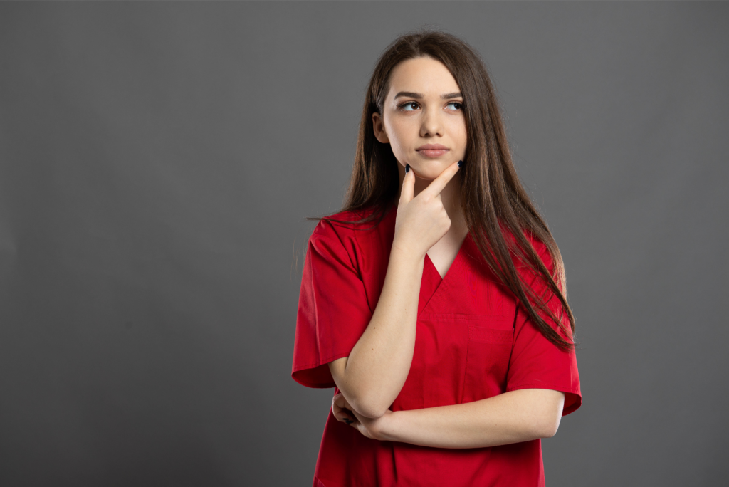 young nurse in scrubs thinking