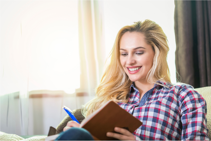 happy smiling woman writing in journal