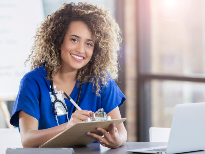 smiling travel nurse doing paperwork