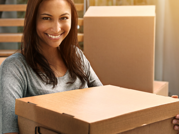 smiling woman carrying box