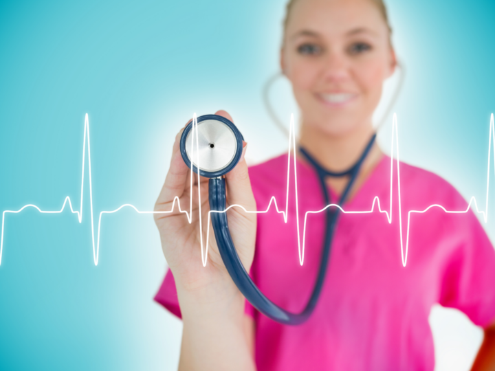 nurse in pink scrubs holding up stethoscope