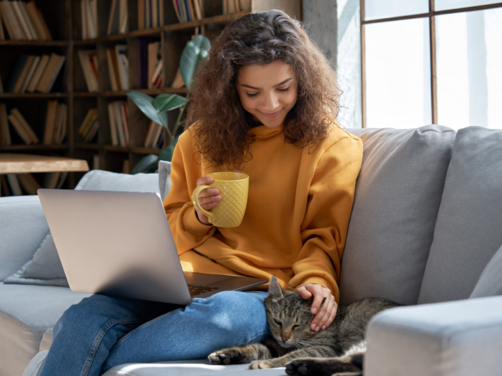 woman sitting on couch stroking her cat